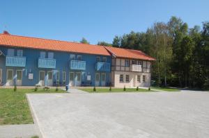 um grande edifício azul com um parque de estacionamento em frente em Nidos stiegė em Nida