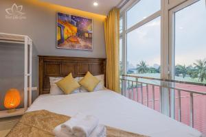 1 dormitorio con 1 cama grande y balcón en The Lakeview - West Lake Lotus Apartments, en Hanói