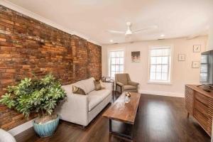 a living room with a couch and a brick wall at Luxury Design Focused, Detroit Themed Apt Near Downtown In the art District in Detroit