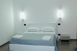 een slaapkamer met een bed met twee lampjes aan de muur bij Beauty House in Reggio di Calabria