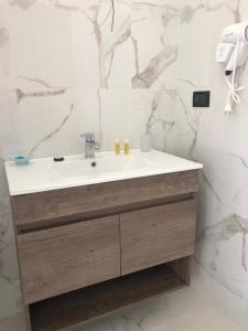 bagno con lavandino bianco e pareti in marmo di Beauty House a Reggio di Calabria