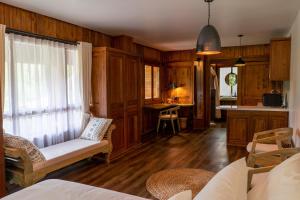 KintamaniにあるTira Vilagna Suites & Spaのウッドパネルの壁のリビングルーム、キッチンが備わります。 +37枚の写真