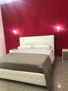 een slaapkamer met een wit bed en een rode muur bij Beauty House in Reggio di Calabria