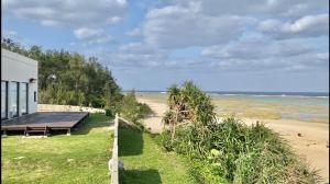 a view of a beach with a building and the ocean at ゴールデンマイルヴィラ in Amami