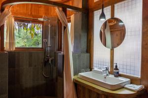 KintamaniにあるTira Vilagna Suites & Spaのバスルーム(シンク、シャワー、鏡付)