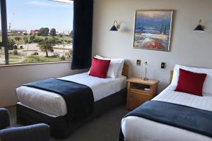 a hotel room with two beds and a window at Baywatch Motor Lodge in Timaru