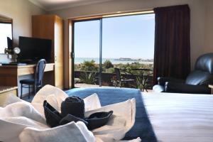 Habitación de hotel con cama y vistas al océano en Baywatch Motor Lodge, en Timaru