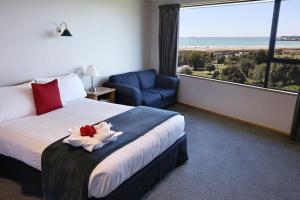 a hotel room with a bed and a large window at Baywatch Motor Lodge in Timaru
