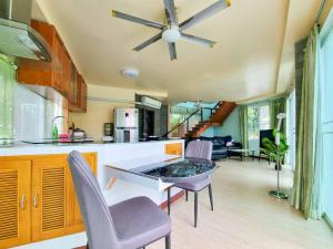 a kitchen and living room with a ceiling fan at Tina's Living Paradise - Guesthouses with private pool in Ban Phe