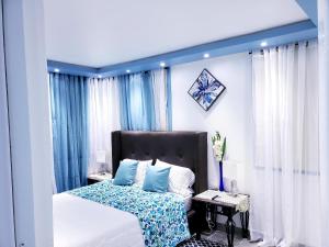 M/H HOUSE (#2) cozy house near airport and beach في كارولينا: غرفة نوم مع سرير مع اللوح الأمامي الأزرق