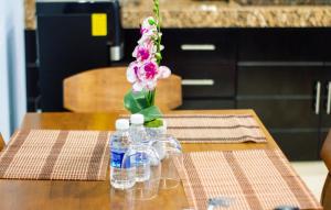 a table with a vase of flowers and bottles of water at APARTAMENTOS MICHAEL in Palenque