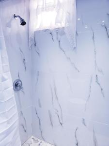 a bathroom with a shower with white marble at M/H HOUSE (#2) cozy house near airport and beach in Carolina +39 photos