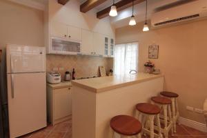 a kitchen with a counter and a refrigerator and stools at Beautiful Life B&B in Dongshan