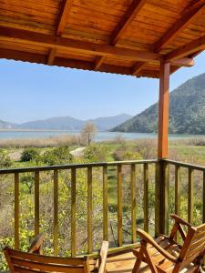 a porch with two chairs and a view of a lake at Lake Wood House in Muğla