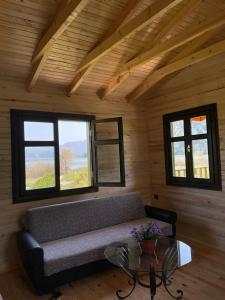 a room with a couch in a room with windows at Lake Wood House in Muğla