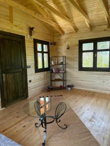 um quarto com uma mesa de vidro e cadeiras num camarote em Lake Wood House em Muğla