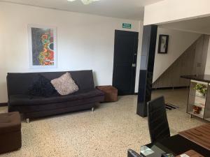 Una sala de estar con un sofá y una escalera. en Casa Melodía Guatapé - Excelente Ubicación - Calle del Comercio, en Guatapé