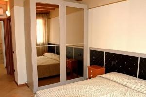 een slaapkamer met 2 bedden en een grote spiegel bij B&B San Marco in Lonigo