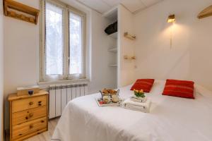 1 dormitorio con 1 cama blanca grande con almohadas rojas en La Maisonnée de Julie - Happy Rentals, en Chamonix-Mont-Blanc