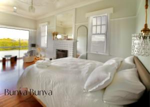Bunya Bunya Luxury Estate Toowoomba set over 2 acres with Tennis Court في توومبا: غرفة نوم بيضاء مع سرير كبير مع وسائد