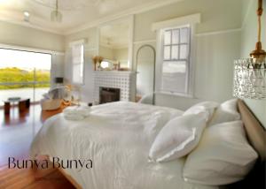 a white bedroom with a large bed with pillows at Bunya Bunya Luxury Estate Toowoomba set over 2 acres with Tennis Court in Toowoomba