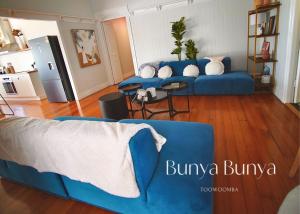a living room with a blue couch and tables at Bunya Bunya Luxury Estate Toowoomba set over 2 acres with Tennis Court in Toowoomba +30 photos