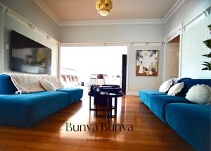 a living room with two blue couches and a table at Bunya Bunya Luxury Estate Toowoomba set over 2 acres with Tennis Court in Toowoomba