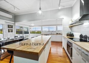 a kitchen with white cabinets and a wooden counter top at Bunya Bunya Luxury Estate Toowoomba set over 2 acres with Tennis Court in Toowoomba