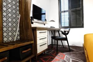 a desk with a computer and a chair in a room at Kosenda Hotel in Jakarta