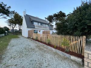 een wit huis met een hek ervoor bij La Villa du Bois d'Amour in Quiberon