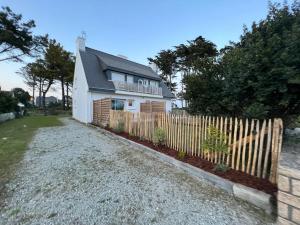 a white house with a fence in front of it at La Villa du Bois d'Amour in Quiberon