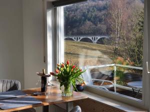 a dining room with a table and a window with a view of a bridge at Apartement Willingen in Stryck