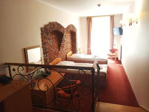 1 dormitorio con cama y pared de ladrillo en Hotel Bartis en Bartoszyce