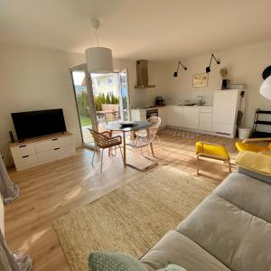 een woonkamer met een bank en een tafel en stoelen bij Ferienwohnung Am bayrischen Meer in Übersee