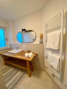 La salle de bains est pourvue d'un lavabo et d'un miroir. dans l'établissement Ferienwohnung Am bayrischen Meer, à Übersee
