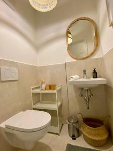 een badkamer met een toilet, een wastafel en een spiegel bij Ferienwohnung Am bayrischen Meer in Übersee