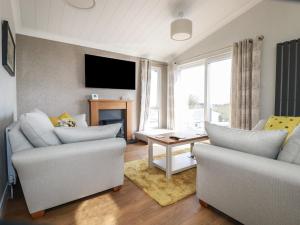 a living room with two couches and a tv at Acorn Lodge in Redruth