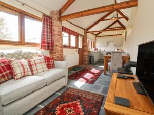 un soggiorno con divano e tavolo di Middle Burrow Cottage a Minehead