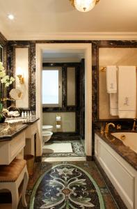 a bathroom with a tub and a toilet and a sink at Bentley London in London