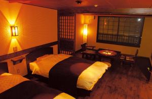 1 dormitorio con 2 camas, mesa y ventana en Hotel Gozensui, en Akankohan