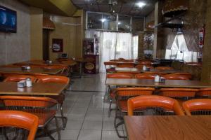 ein leeres Restaurant mit Holztischen und -stühlen in der Unterkunft Hotel Acuarius in La Plata