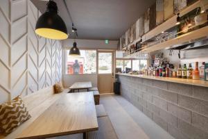 a restaurant with a wooden table and a counter at Coliving & Cafe SANDO in Imabari