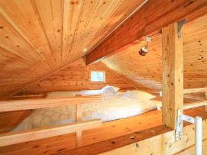 a bed in a log cabin with wooden ceilings at 石垣島コテージAkeeesi365 LOG in Ishigaki Island