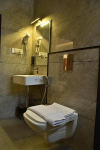 a bathroom with a toilet and a sink at Sukhi A Luxury Stay Inn in Chikmagalūr