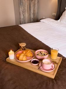uma bandeja com alimentos para o pequeno-almoço e uma vela numa cama em Keremet Hotel em Almaty