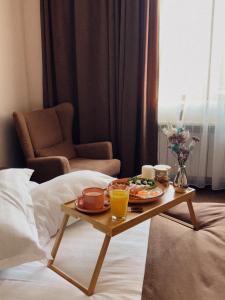 uma bandeja de comida numa mesa numa cama em Keremet Hotel em Almaty