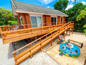 a house with a large deck with two kids on a pool at 石垣島コテージAkeeesi365 LOG in Ishigaki Island