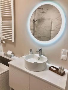 a bathroom with a white sink and a mirror at Apartament Rzeszów Centrum in Rzeszów