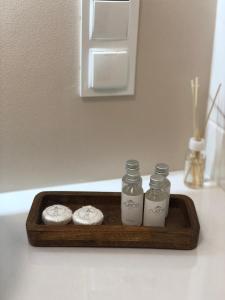 a wooden tray with three bottles on a counter at Apartament Rzeszów Centrum in Rzeszów