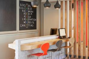 a reception desk with two chairs and a laptop at ibis Strasbourg Centre Historique in Strasbourg +77 photos